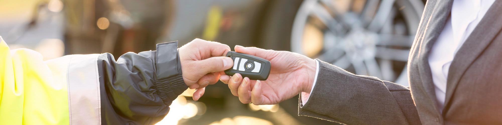 man giving man a car key