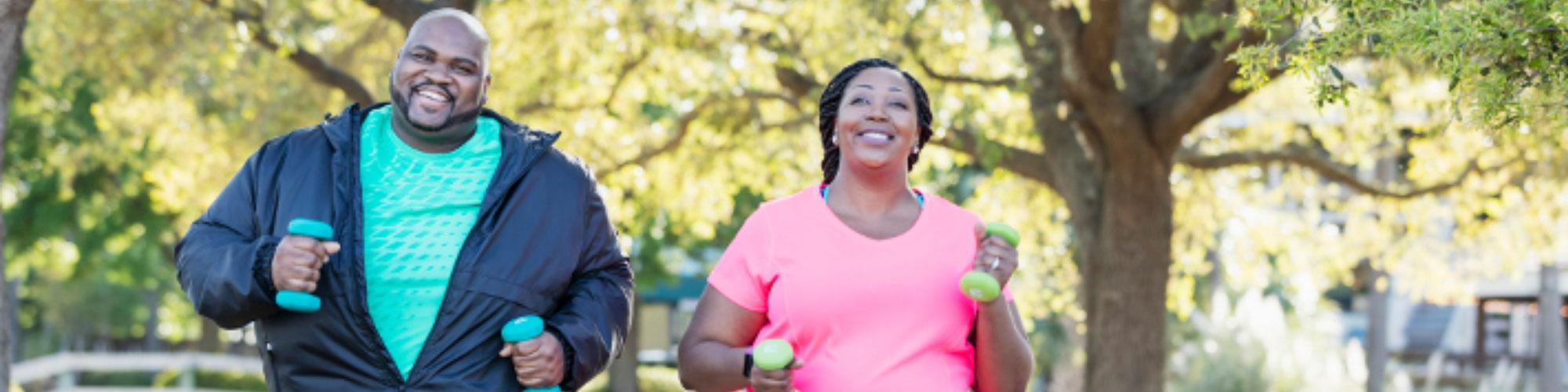 African American Couple Walking with Hand Weights