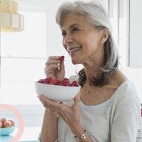 a senior lady smiling and eating healthy